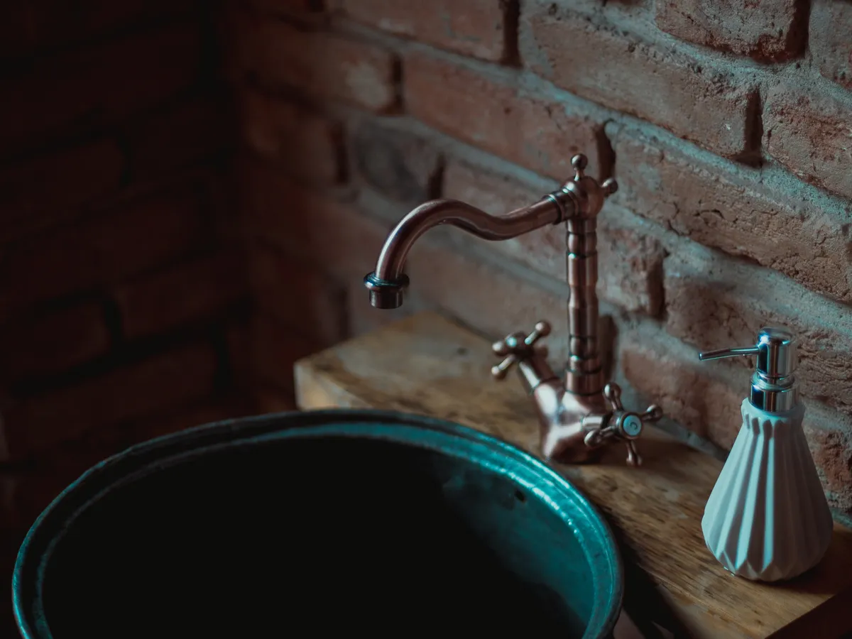 Rustic sink and faucet representing plumbing repair